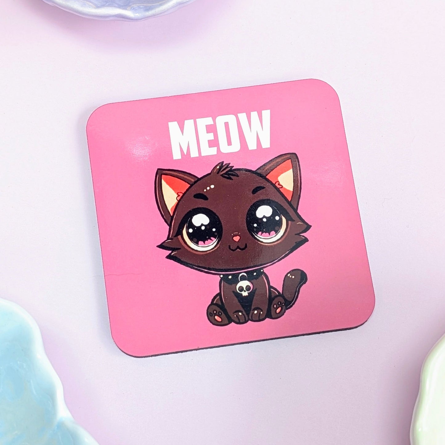 Pink coaster with a cartoon cat and 'MEOW' text on a light pink background