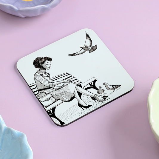 Whimsical Woman Feeding Pigeons Coaster – Hand Drawn Vintage Park Bench Illustration