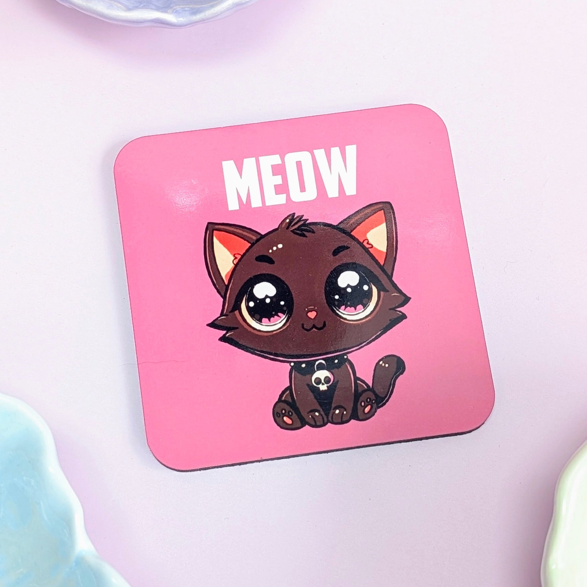 Pink coaster with a cartoon cat and 'MEOW' text on a light pink background