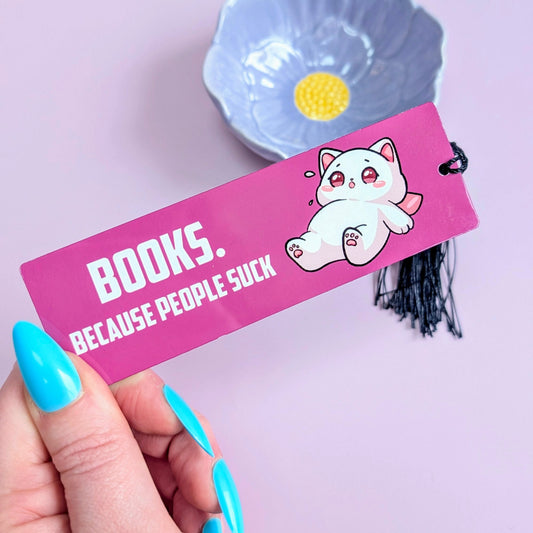 Hand holding a pink bookmark with cartoon character and text against a light purple background